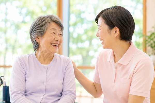 高齢者と笑顔で語らう介護職員